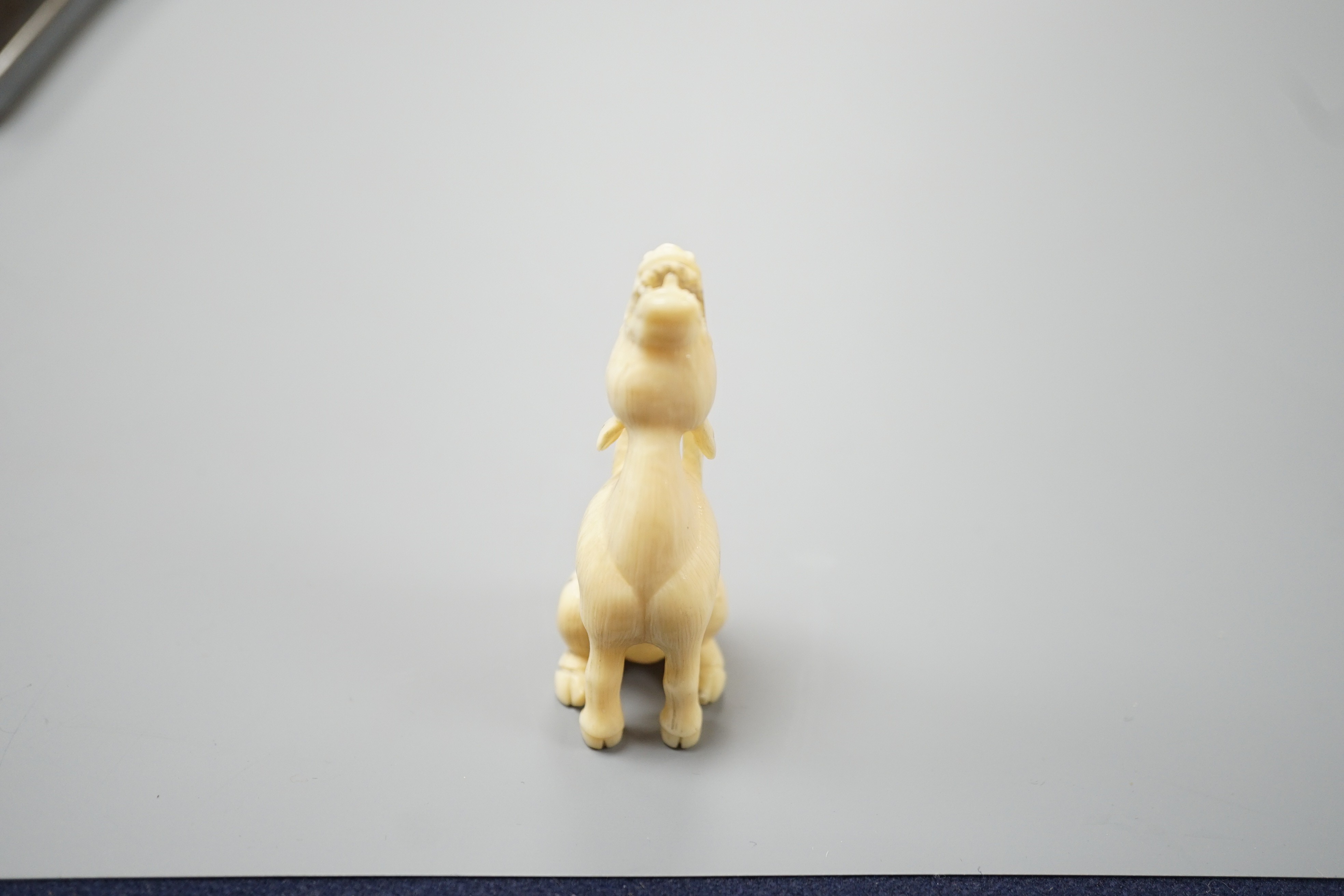A Japanese ivory netsuke of a seated bellowing deer, 19th century, bears signature, 5.8cm